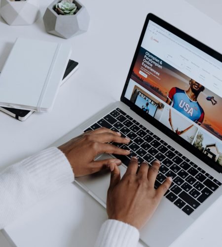 Close-up of hands typing on a laptop in a modern workspace. Minimalist, clean aesthetic.